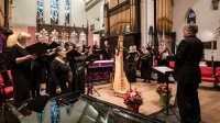 Ein Kirchenmusiker leitet einen Chor in einer Kirche an.