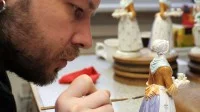 Ein Manufakturporzellanmaler bemalt die Kleidung der Porzellanfigur "Schokoladenmädchen" in der Staatlichen Porzellan-Manufaktur Meissen.