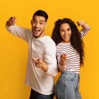 Fröhliches Paar, das mit den Fingern in die Kamera zeigt