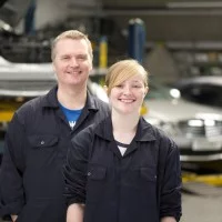 Auszubildende und Ausbilder vor Autos