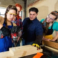 Auzubildende bohrt in ein Brett