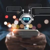 Eine Person hält ein Smartphone und chattet mit einem Chatbot.