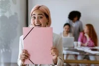 Ein Bewerberin mit Bewerbungsmappe freut sich