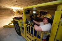 Eine Bergbautechnologin fährt im Werk Werra der K+S KALI GmbH einen Firstankerbohrwagen, der für die untertägige Gewinnung, Sicherung und Erkundung genutzt wird.