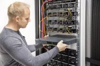 Ein Assistenten für Softwaretechnik schiebt die Hardware in den Server.