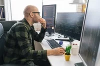 Ein mathematisch-technischer Assistent entwickelt in seinem Büro ein Softwareprogramm am Computer.