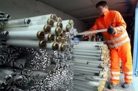 Eine Fachkraft für Abfallwirtschaft stapelt alte Leuchtstoffröhren auf dem Wertstoffhof in Stuttgart-Münster.