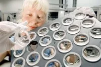 Eine Feinoptikerin prüft Linsen im Werk der Carl Zeiss Jena GmbH.