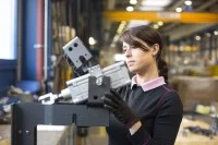 Eine Feinwerkmechanikerin stellt Kurztaktpressen für die Laminatindustrie her.