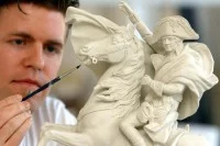 In der Porzellanmanufaktur Sitzendorf formt ein Mitarbeiter das noch ungebrannte Motiv "Napoleons Ritt über die Alpen".