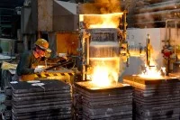 Ein Gießereimechaniker gießt hoch erhitztes Metall in eine Form für ein Werkstück.