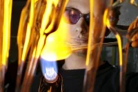 Ein Glasapparatebauer erhitzt einen Glaskolben, um ihn formbar zu machen.