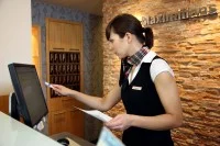 Eine Hotelfachfrau arbeitet am Empfang in einem Hotel in Essen.