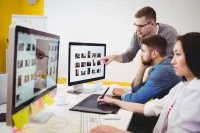 Eine Kauffrau für audiovisuelle Medien bearbeitet eine Bilddatei mit einem Grafiktablett.