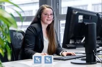 Eine Kauffrau im Gesundheitswesen berät eine Kundin der Techniker Krankenkasse in Hamburg telefonisch.