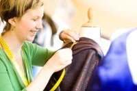 Eine Maßschneiderin überprüft die Maße eines neuen Kleidungsstücks.