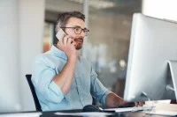 Ein Industriekaufmann telefoniert am Arbeitsplatz