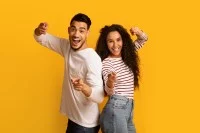 Fröhliches Paar, das mit den Fingern in die Kamera zeigt