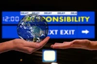 Eine Hand hält einen Erdball vor einer Anzeigetafel