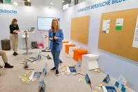 Julia Olesen steht in der Lieferkette und erklärt den Teilnehmenden des Workshops die Aufgabe.