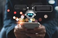 Eine Person hält ein Smartphone und chattet mit einem Chatbot.