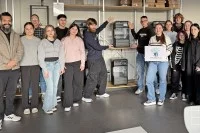 Lehrkräfte und Schülerinnen und Schüler der Louis-Lepox-Schule vor einem 3-D-Drucker