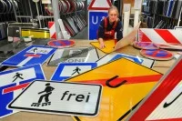 Eine Schilder- und Lichtreklameherstellerin arbeitet in den Schilderwerken Beutha an einem Auftrag für neue Verkehrsschilder.
