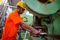 Ein Stanz- und Umformmechaniker arbeitet an der Lochstanzmaschine.