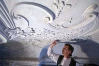 Ein Stuckateur arbeitet an der Sanierung der Stuckdecke in Schloss Bothmer bei Klütz.