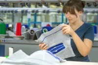 Eine Textil- und Modenäherin prüft die Qualität einer Kniebandage. 