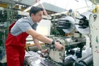 Ein Kunststoff- und Kautschuktechnologe bedient eine Maschine zum Zuschneiden von Kunststofffolie.