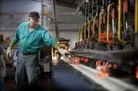 Ein Verfahrensmechaniker Glastechnik prüft ein Glas für Babynahrung kurz nach dem Schmelzvorgang.