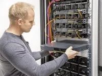 Ein Assistenten für Softwaretechnik schiebt die Hardware in den Server.