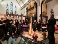 Ein Kirchenmusiker leitet einen Chor in einer Kirche an.