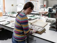 Eine Mitarbeiterin arbeitet in der Bildabteilung des Staatsarchivs Hamburg.