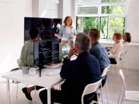 Eine kaufmännische Assistentin / Wirtschaftsassistentin für Betriebsinformatik hält für fünf Personen eine Schulung über das neue Softwareprogramm.