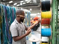 Eine Fachkraft für Metalltechnik prüft die Qualität eines Drahts.