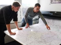 Zwei Geomatiker vom Landesbetrieb Straßenbau Nordrhein-Westfalen überprüfen eine Landkarte, die sie erstellt haben.