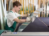 Ein Glaser prüft die Qualität einer Scheibe.