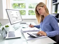 Eine Industriekauffrau prüft Rechnungen in ihrer Firma.