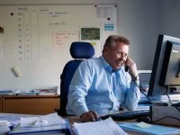 Ein Kaufmann im Eisenbahn- und Straßenverkehr bei DB Schenker organisiert den Warentransport mit Zügen.