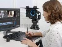 Eine Mediengestalterin Bild und Ton bearbeitet ein Video mit einem Grafiktablett.