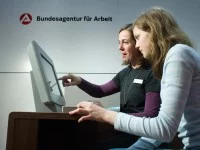 Eine Fachangestellte für Arbeitsmarktdienstleistungen berät eine Jugendliche an einem Stand der Bundesagentur für Arbeit über Ausbildungsberufe.