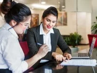 Eine Rechtsanwalts- und Notarfachangestellte geht mit einer Mandantin den aufgesetzten Vertrag durch.