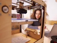 Eine Technische Produktdesignerin überwacht den 3-D-Druck eines Prototyps.