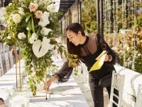 Eine Veranstaltungskauffrau überprüft den für eine Feier festlich gedeckten Tisch.