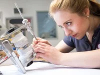 Damit die Zahnprothese später auch perfekt passt, simuliert eine Zahntechnikerin in einem Artikulator die Bewegungen des Kiefergelenks.